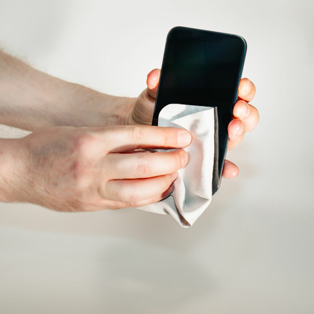 Hand wiping a touchscreen device with a soft cloth before applying a screen protector