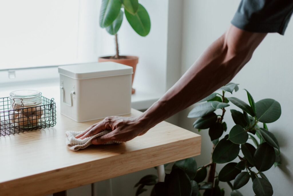 Hand wiping a wooden surface with a soft cloth
