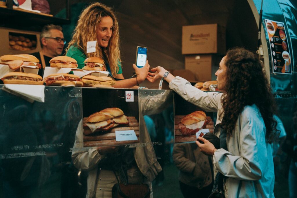 Customer making a digital payment at an outdoor food truck counter